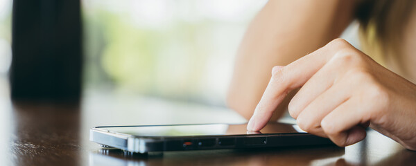 Asian young woman using smart phone for shopping online at cafe coffee shop in the morning, female has transfer money financial internet banking on mobile phone
