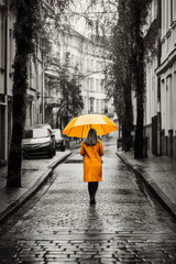 Yellow umbrella in hand of woman walking on a colorless street. AI generative