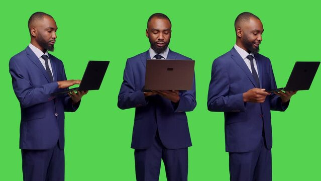 Startup manager in suit working with laptop on camera and browsing online network page with wireless pc. Young business employee using online website with portable computer, green screen.
