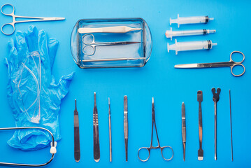 medical instruments, goggles, and gloves on blue background. View from above