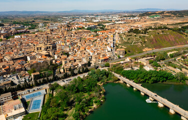 Fototapeta na wymiar Scenic drone view of Spanish city of Tudela located in Ebro river valley overlooking ancient arched stone bridge and Roman Catholic cathedral in historic center on sunny spring day, Navarre