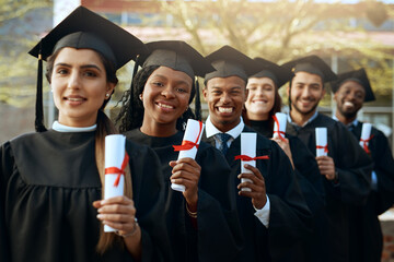 And now the working working world awaits. Portrait of a group of young students holding their diplomas on graduation day.