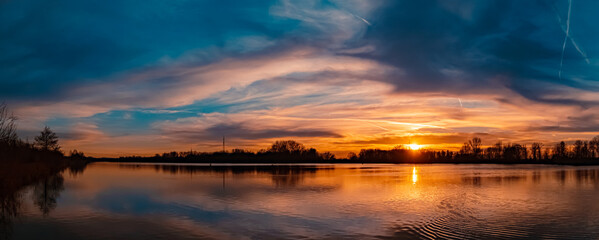 High resolution stitched winter sunset panorama with reflections near Plattling, Isar, Bavaria, Germany