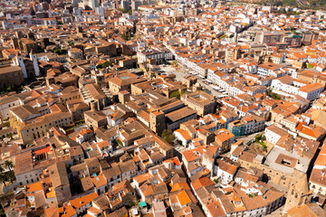 Scenic aerial view of ancient quarter of Spanish city of Caceres overlooking brownish tiled roofs...