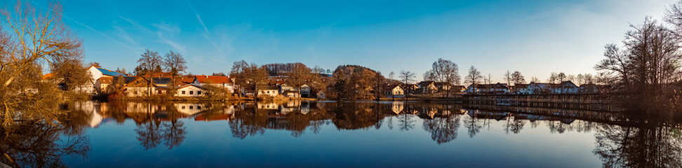 Fototapeta na wymiar Winter landscape on a sunny day with reflections in a pond near Wiesenfelden, Bavarian forest, Straubing-Bogen, Bavaria, Germany