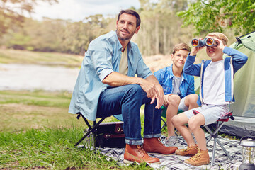 Its guy time. a father and his two sons out camping in the woods.