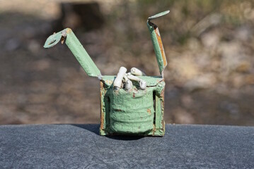 one old green metal electronic part stands on a black table in the street