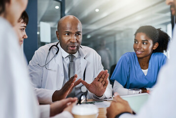 Obraz premium Going through a medical plan of action. a group of doctors having a meeting in a hospital.