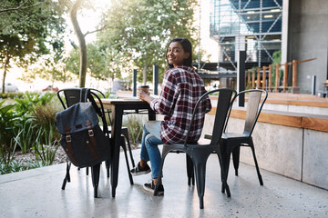 Obraz premium If Im not in class, then Im most likely here. Rearview portrait of an attractive young female student studying at a table outside on campus.