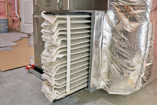 High efficiency furnace air filter pulled partially out for inspection and cleaning