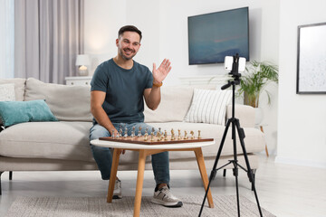 Teacher near chessboard conducting online lesson at home. Time for hobby