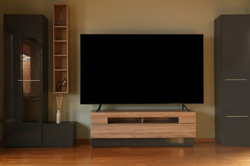 Modern TV set on table in room. Interior design