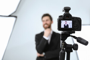 Handsome happy model posing for camera in modern studio, selective focus. Professional photo session