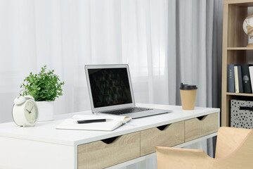 Workplace with modern laptop on desk at home