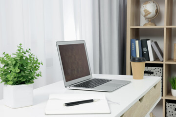 Workplace with modern laptop on desk at home