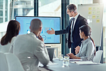 Using visual aid is always a plus. a businessman delivering a presentation in the boardroom.