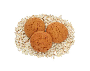 Delicious oatmeal cookies and flakes on white background, top view