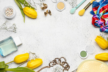 Frame made of stylish female accessories, cosmetics and flowers on light background