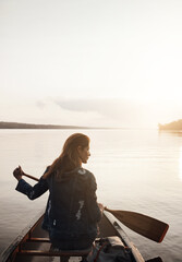 Nature offers a unique kind of therapy. Rearview shot of a young woman enjoying a canoe ride at the lake.