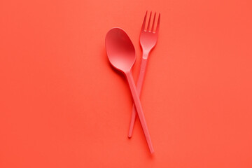 Spoon and fork on color background