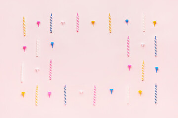 Frame made of colorful birthday candles on pink background