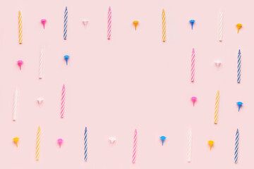 Frame made of colorful birthday candles on pink background