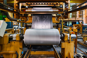 Rolling reinforced sheet on reel drum with rubber band