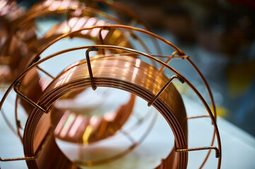 Shiny brass welding wire coil on table in supplies store