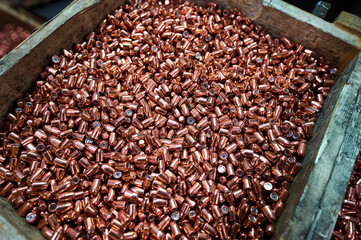 Bullets in large wooden crate at weapon production plant