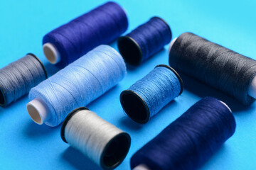 Composition with different thread spools on color background, closeup