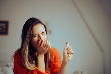 Woman Covering Nose Spraying Perfume Indoors at Home. Motel guest trying to refresh the smell...