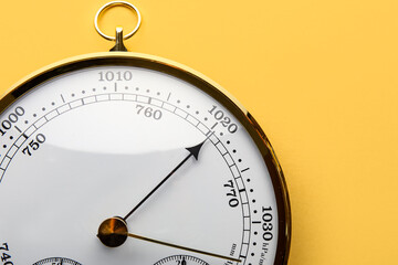 Aneroid barometer on yellow background