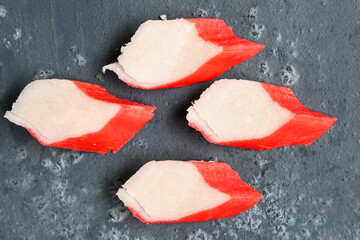 Pieces of tasty crab sticks on green background, closeup © Pixel-Shot