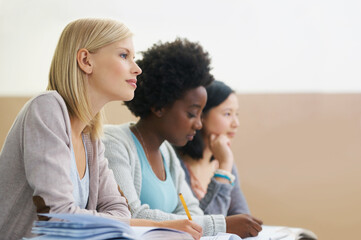 Class is in session. female university students sitting in an exam room.