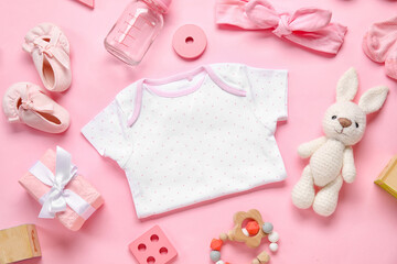 Composition with baby clothes, toys and accessories on light pink background
