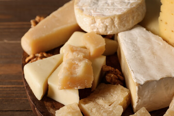 Plate with different types of tasty cheese on table, closeup