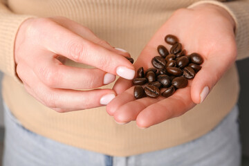 Woman holding coffee beans, closeup