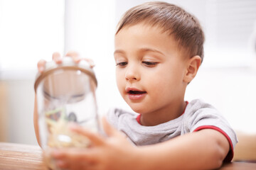 Inspecting nature. a cute young boy with a jar full of toys.