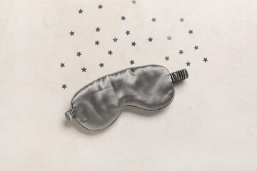 Sleeping mask and confetti on light background