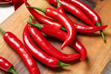 Board of fresh hot chili peppers on white background