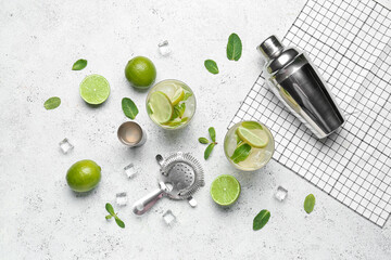 Glasses of tasty mojito and ingredients on light background