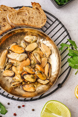 Plate of pickled mussels on grey background