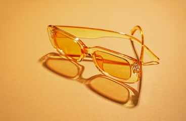 Modern sunglasses on orange background