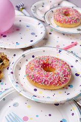 Paper disposable plates with doughnut on grunge background, closeup