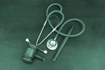 Broken wooden gavel and stethoscope on table, top view. Malpractice and medicine out of law concept.
