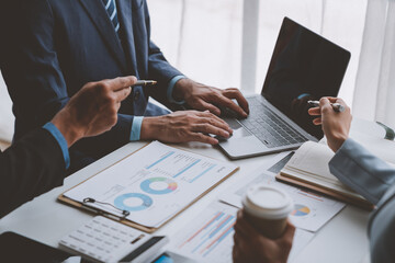 Group of businessmen, investors discussing and meeting based on documents laptop to analyze and discuss financial report situation in conference room accounting concept.