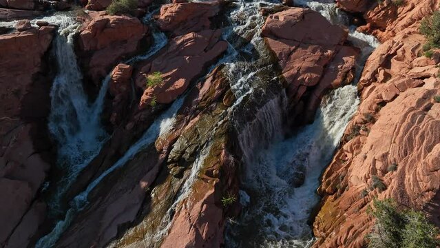 Aerial view looking down at Gunlock Falls in southern Utah as water flows through the red rocks during Spring runoff.