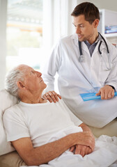 Obraz premium Its important you get plenty of rest...a handsome male doctor with an elderly patient.