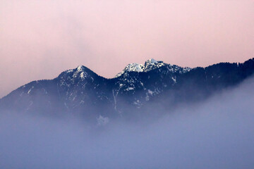 Fototapeta na wymiar Snowcapped Mountains, Pink Sky and Fog