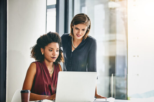 Finding the right solutions to meet their targets on time. two businesswomen working together on a laptop in an office.